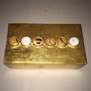 gold metal box with decorative discs on lid